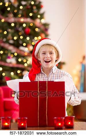 Young boy opening a Christmas present on Christmas day View Large Photo Image Stock Image - Young boy opening a Christmas present on Christmas day. Fotosearch