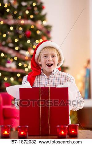 Young boy opening a Christmas present on Christmas day View Large Photo Image Stock Image - Young boy opening a Christmas present on Christmas day. Fotosearch