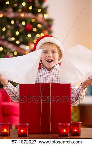 Young boy opening a Christmas present on Christmas day View Large Photo Image Stock Photo - Young boy opening a Christmas present on Christmas day. Fotosearch