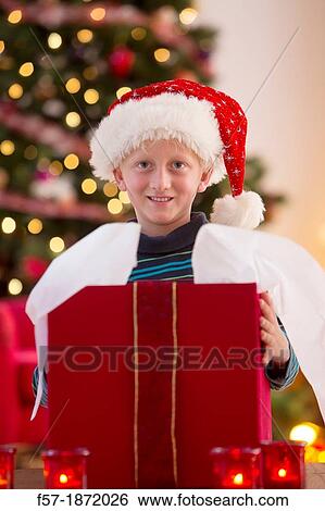 Young boy opening a Christmas present on Christmas day View Large Photo Image Stock Photograph - Young boy opening a Christmas present on Christmas day. Fotosearch