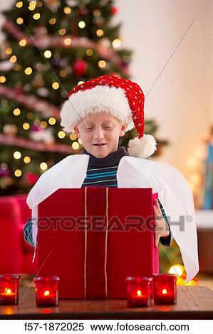 Young boy opening a Christmas present on Christmas day View Large Photo Image Stock Photography - Young boy opening a Christmas present on Christmas day. Fotosearch