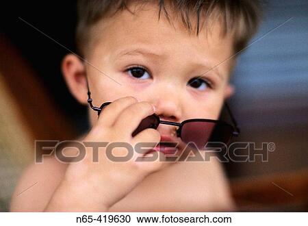 Young boy peering over sunglasses. View Large Photo Image Stock Image - Young boy peering over sunglasses.. Fotosearch