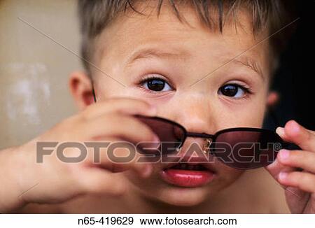 Young boy peering over sunglasses. View Large Photo Image Stock Photo - Young boy peering over sunglasses.. Fotosearch