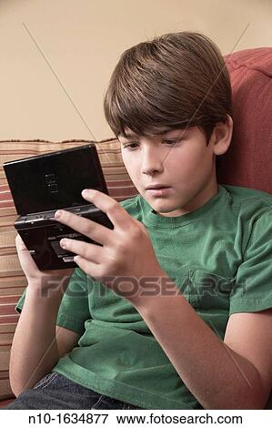 Young boy playing a video game View Large Photo Image Stock Photo - Young boy playing a video game. Fotosearch