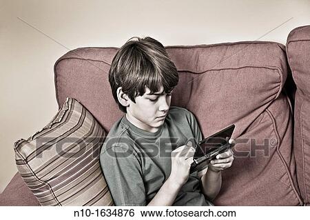 Young boy playing a video game View Large Photo Image Stock Photograph - Young boy playing a video game. Fotosearch
