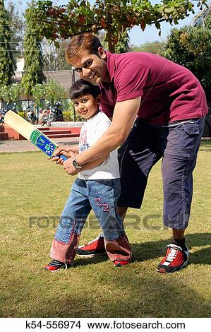 Young boy playing cricket with his father. View Large Photo Image Picture - Young boy playing cricket with his father.. Fotosearch