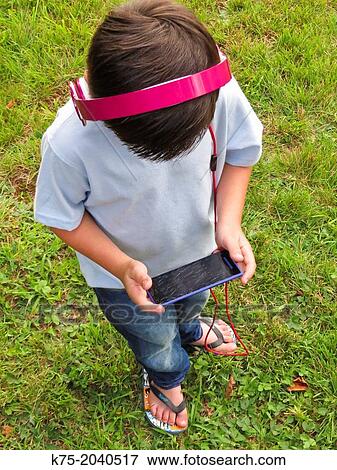 Stock Photo - Young boy playing game on computer. Fotosearch