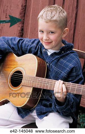 Stock Photo - Young boy playing guitar. Fotosearch