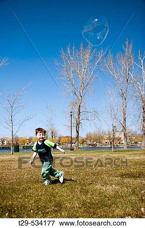 Young boy playing in the park View Large Photo Image Stock Photo - Young boy playing in the park. Fotosearch