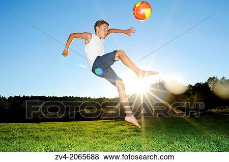 Young boy playing soccer on a meadow, Germany. View Large Photo Image Stock Photo - Young boy playing soccer on a meadow, Germany.. Fotosearch
