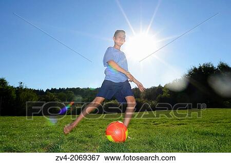 Young boy playing soccer on a meadow, Germany. View Large Photo Image Stock Photo - Young boy playing soccer on a meadow, Germany.. Fotosearch