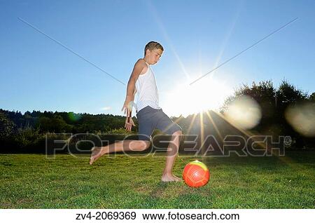 Young boy playing soccer on a meadow, Germany. View Large Photo Image Stock Photo - Young boy playing soccer on a meadow, Germany.. Fotosearch