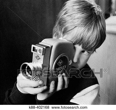 Stock Photo - Young boy playing with film camera, Sweden. Fotosearch