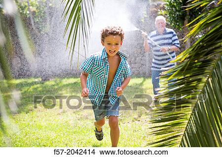 Young boy playing with his grandfather in the garden. View Large Photo Image Picture - Young boy playing with his grandfather in the garden.. Fotosearch