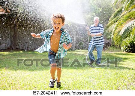 Young boy playing with his grandfather in the garden. View Large Photo Image Stock Image - Young boy playing with his grandfather in the garden.. Fotosearch