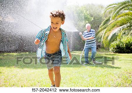 Young boy playing with his grandfather in the garden. View Large Photo Image Stock Image - Young boy playing with his grandfather in the garden.. Fotosearch