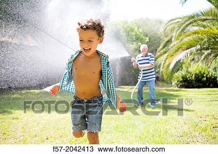 Young boy playing with his grandfather in the garden. View Large Photo Image Stock Image - Young boy playing with his grandfather in the garden.. Fotosearch