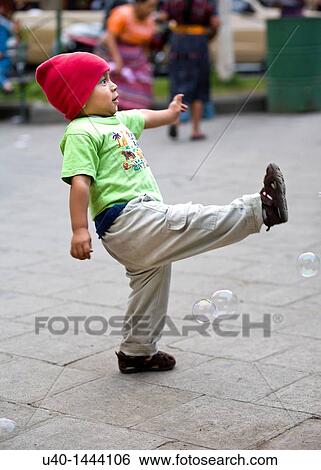 Young boy playing with soap bubbles View Large Photo Image Stock Photograph - Young boy playing with soap bubbles. Fotosearch