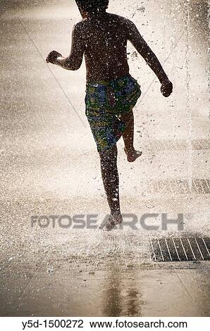 young boy running forward under water drops falling from fountains, in front of Palace of Nations, Geneva, Switzerland View Large Photo Image Stock Image - young boy running forward under water drops falling from fountains, in front of Palace of Nations, Geneva, Switzerland. Fotosearch
