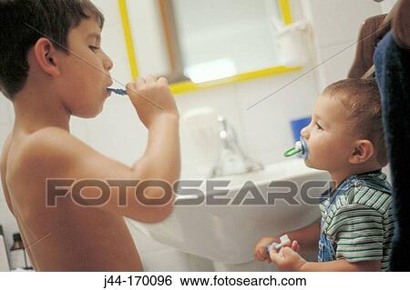 Young boy showing his brother how to brush his teeth View Large Photo Image Stock Photograph - Young boy showing his brother how to brush his teeth. Fotosearch