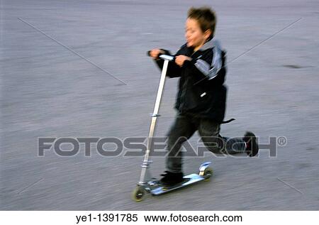 Young boy speeding on a kick scooter View Large Photo Image Stock Photography - Young boy speeding on a kick scooter. Fotosearch