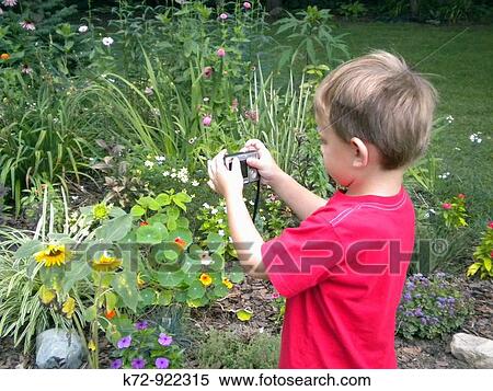 Young boy taking pictures of flowers. View Large Photo Image Stock Photography - Young boy taking pictures of flowers.. Fotosearch