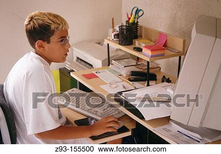 Stock Image - Young boy using computer. Fotosearch