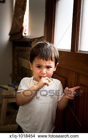 Young boy waiting by the door at home, crying Iceland View Large Photo Image Picture - Young boy waiting by the door at home, crying Iceland. Fotosearch