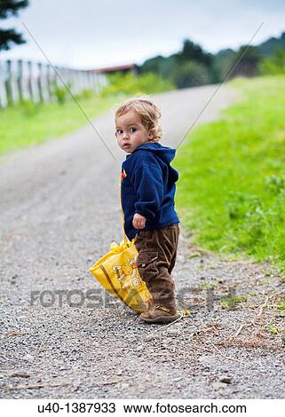 Young boy walking with large bag View Large Photo Image Stock Image - Young boy walking with large bag. Fotosearch