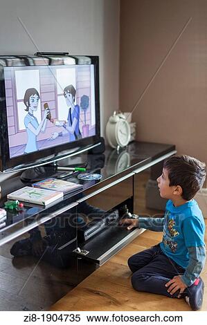 Stock Photography - Young boy watches TV. Fotosearch