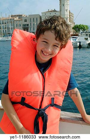 Young boy wearing a life jacket on board a boat, La Ciotat, Provence, France. View Large Photo Image Stock Image - Young boy wearing a life jacket on board a boat, La Ciotat, Provence, France.. Fotosearch