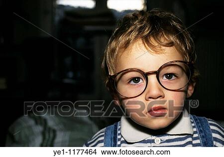 Young boy wearing oversized glasses. View Large Photo Image Picture - Young boy wearing oversized glasses.. Fotosearch