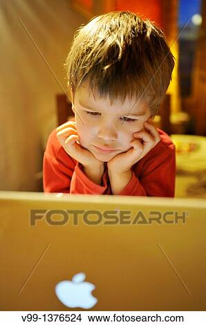 young boy who watches a movie on computer View Large Photo Image Picture - young boy who watches a movie on computer. Fotosearch