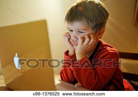 young boy who watches a movie on computer View Large Photo Image Stock Photography - young boy who watches a movie on computer. Fotosearch