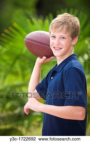 Stock Image - Young boy with american football. Fotosearch