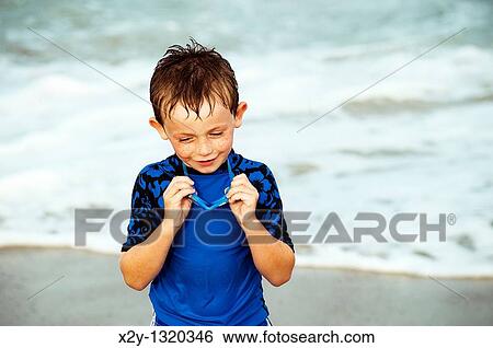 Young boy with goggles enjoys the ocean water View Large Photo Image Stock Photograph - Young boy with goggles enjoys the ocean water. Fotosearch