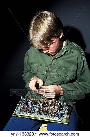 young boy working on a circuit board on his lap View Large Photo Image Stock Photo - young boy working on a circuit board on his lap. Fotosearch