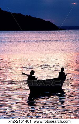 Young boys fishing from a canoe at sunset on a lake in Chile View Large Photo Image Stock Image - Young boys fishing from a canoe at sunset on a lake in Chile. Fotosearch