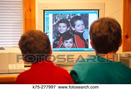 young boys looking at computer monitor View Large Photo Image Stock Photo - young boys looking at computer monitor. Fotosearch