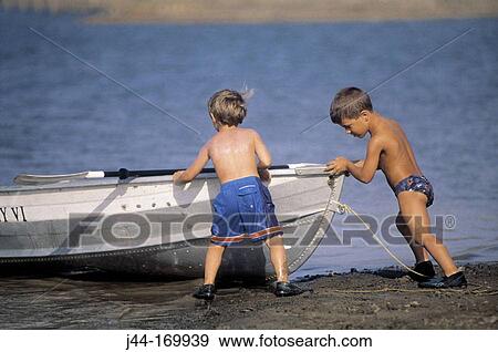 Young boys pushing a boat to the lake View Large Photo Image Stock Photo - Young boys pushing a boat to the lake. Fotosearch