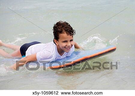 Young Brazilian boy playing on surf board on Copacabana Beach in Rio de Janeiro in Brazil View Large Photo Image Stock Image - Young Brazilian boy playing on surf board on Copacabana Beach in Rio de Janeiro in Brazil. Fotosearch