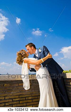 Stock Image - Young bride and groom kissing. Fotosearch