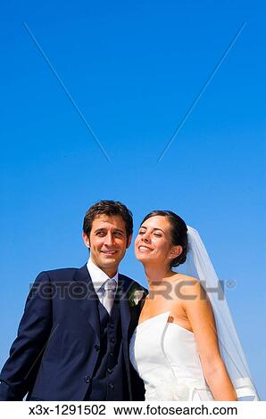 Young bride and groom under blue sky View Large Photo Image Stock Image - Young bride and groom under blue sky. Fotosearch