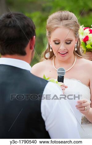 Young bride saying wedding vow to her groom using a microphone View Large Photo Image Stock Image - Young bride saying wedding vow to her groom using a microphone. Fotosearch