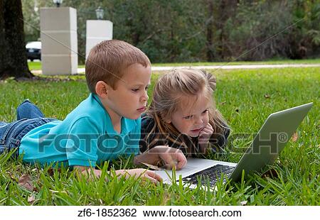 Young brother and sister aged only 5 and 3 playing in front yard with computer and internet games really getting along and interested View Large Photo Image Stock Image - Young brother and sister aged only 5 and 3 playing in front yard with computer and internet games really getting along and interested. Fotosearch