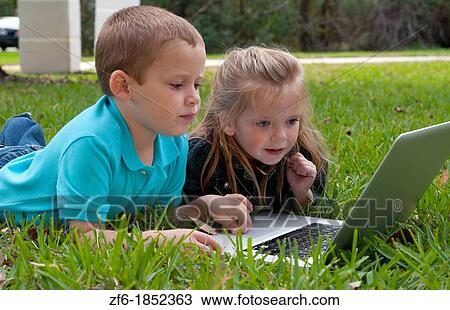 Young brother and sister aged only 5 and 3 playing in front yard with computer and internet games really getting along and interested View Large Photo Image Stock Image - Young brother and sister aged only 5 and 3 playing in front yard with computer and internet games really getting along and interested. Fotosearch
