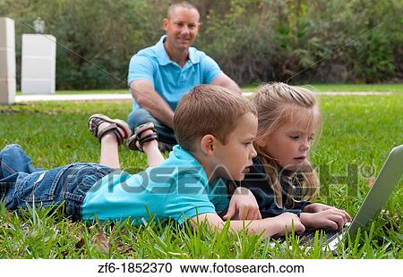 Young brother and sister aged only 5 and 3 playing in front yard with computer and internet games really getting along and interested while father sits in the background happy and proud View Large Photo Image Stock Image - Young brother and sister aged only 5 and 3 playing in front yard with computer and internet games really getting along and interested while father sits in the background happy and proud. Fotosearch