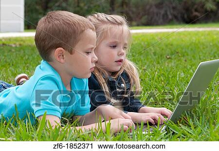 Young brother and sister aged only 5 and 3 playing in front yard with computer and internet games really getting along and interested View Large Photo Image Stock Image - Young brother and sister aged only 5 and 3 playing in front yard with computer and internet games really getting along and interested. Fotosearch