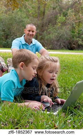 Young brother and sister aged only 5 and 3 playing in front yard with computer and internet games really getting along and interested while father sits in the background happy and proud View Large Photo Image Stock Photo - Young brother and sister aged only 5 and 3 playing in front yard with computer and internet games really getting along and interested while father sits in the background happy and proud. Fotosearch
