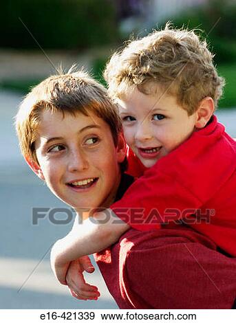 Young brother holding onto big brother's back View Large Photo Image Stock Photo - Young brother holding onto big brother's back. Fotosearch